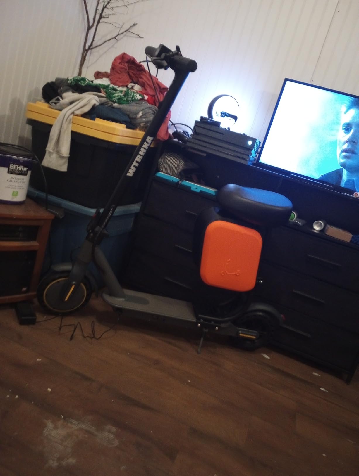 WTRHXA W2 with seat and orange bag standing in a living room beside a TV stand