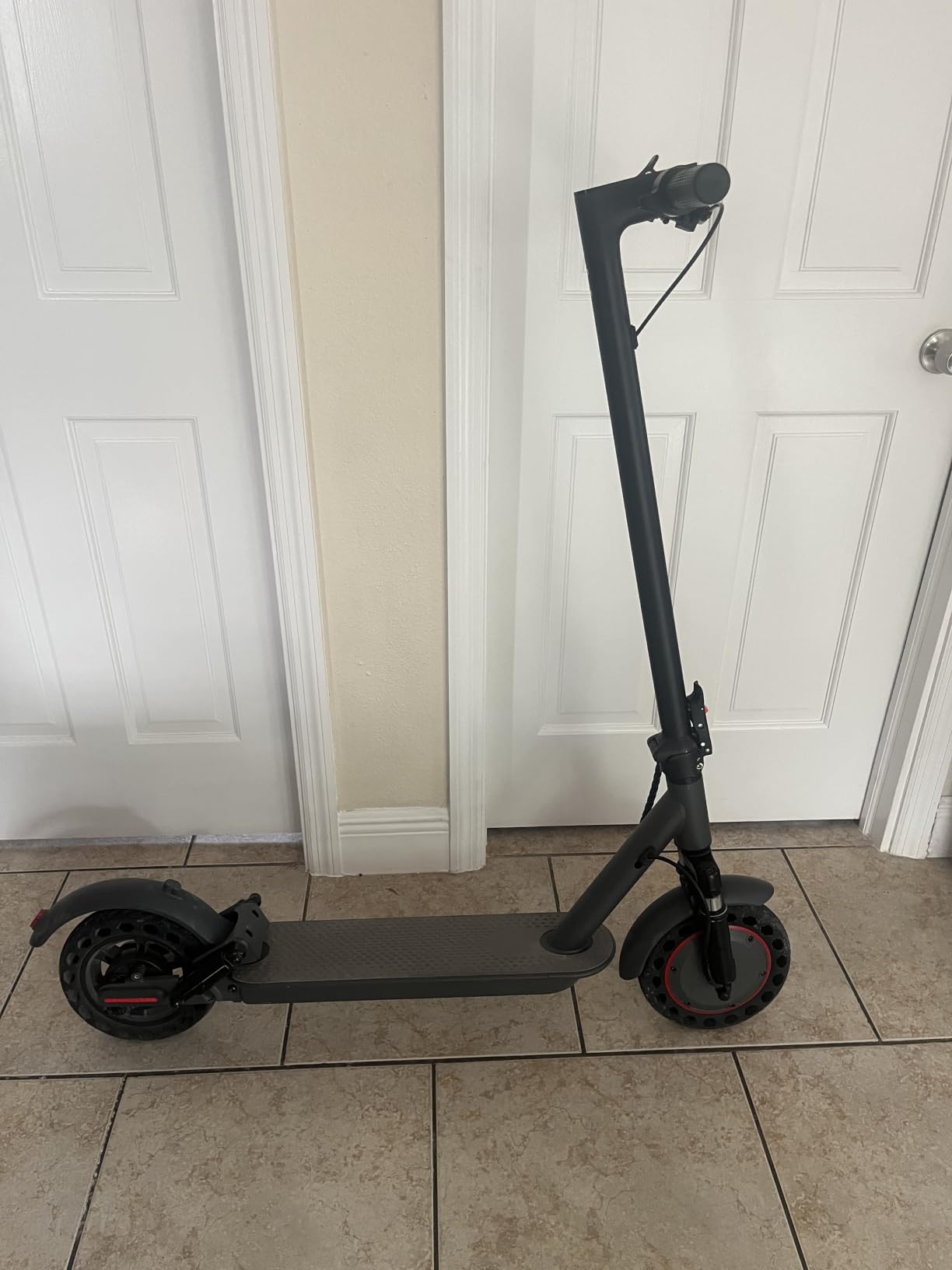 Gray WTRHXA electric scooter on its kickstand in a tiled hallway