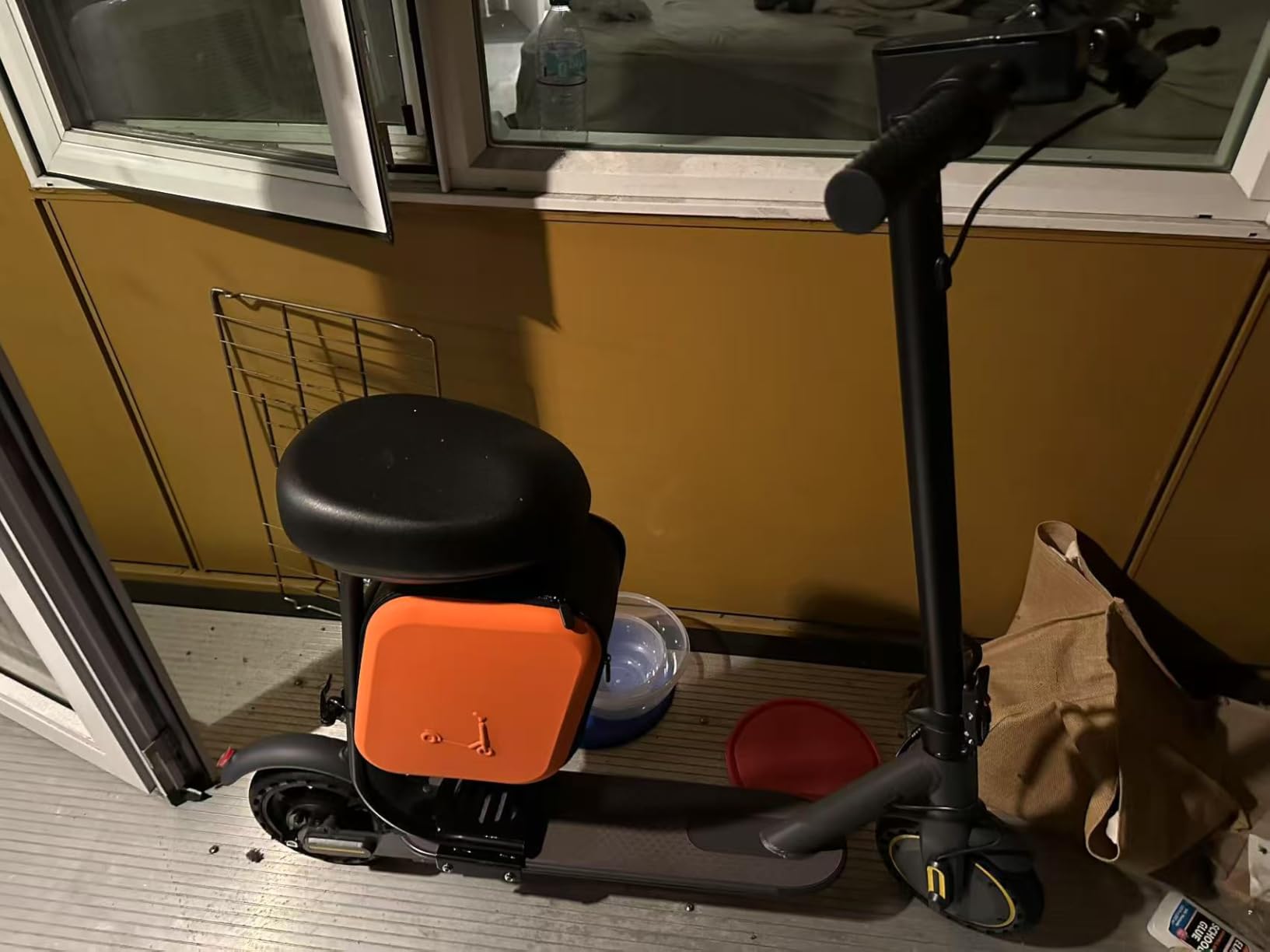 WTRHXA W2 with seat and orange storage bag parked on an apartment balcony at night