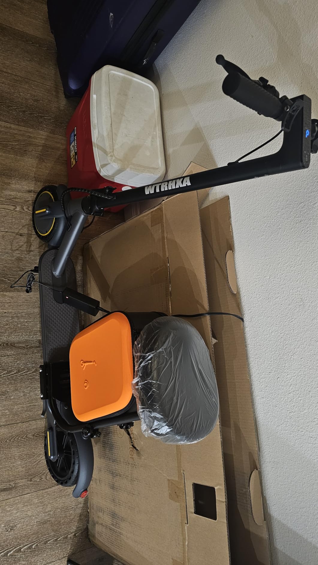 Freshly unpacked WTRHXA W2 with seat and bag lying folded on its box on a wood floor
